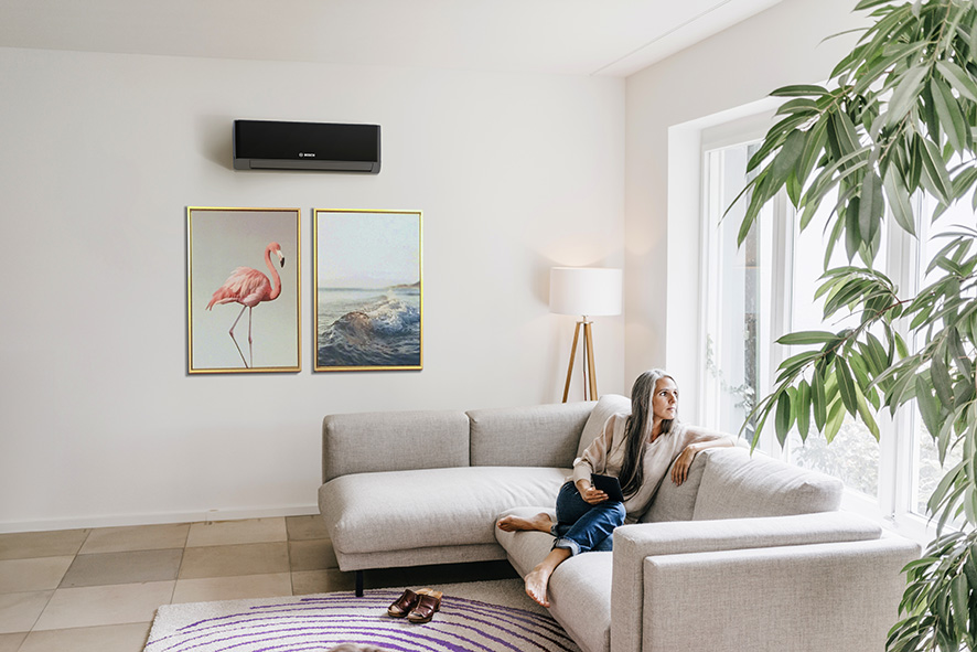 Woman relaxing at home with Worcester Bosch Climate 7000i air conditioning