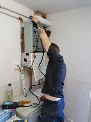 Engineer working on wall-mounted boiler installation